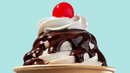 Succulent ice cream sundae with chocolate drizzle and a cherry on top.