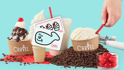 A colorful advertisement for CARVEL ice cream, featuring a cup of soft serve and scoops on the ground next to it. There's a whimsical fish floating above, and a person's hand is in the process of sprinkling something onto the dessert.